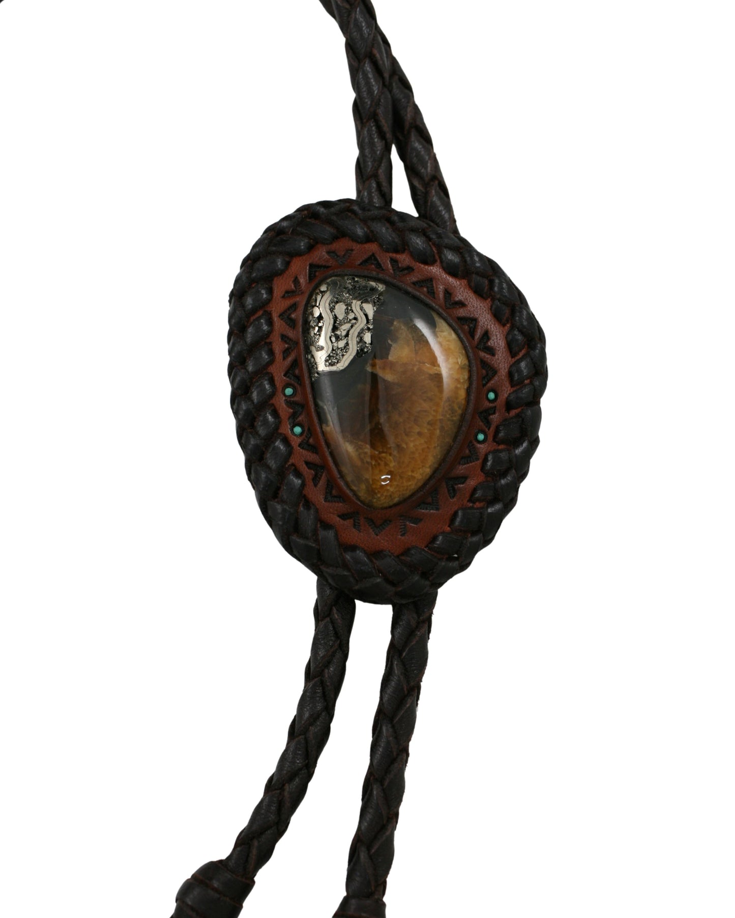 Close-up of a hand-tooled leather bolo tie featuring a Simbircite and Pyrite stone centerpiece by Kelly Horrigan Handmade, shown on white background.