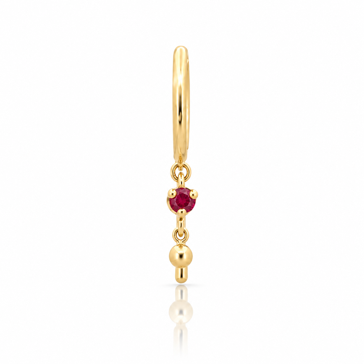 Single 14k yellow gold Baby Chime hoop earring by JACK & G featuring a 2mm natural red ruby in a prong setting with delicate dangling gold ball details.