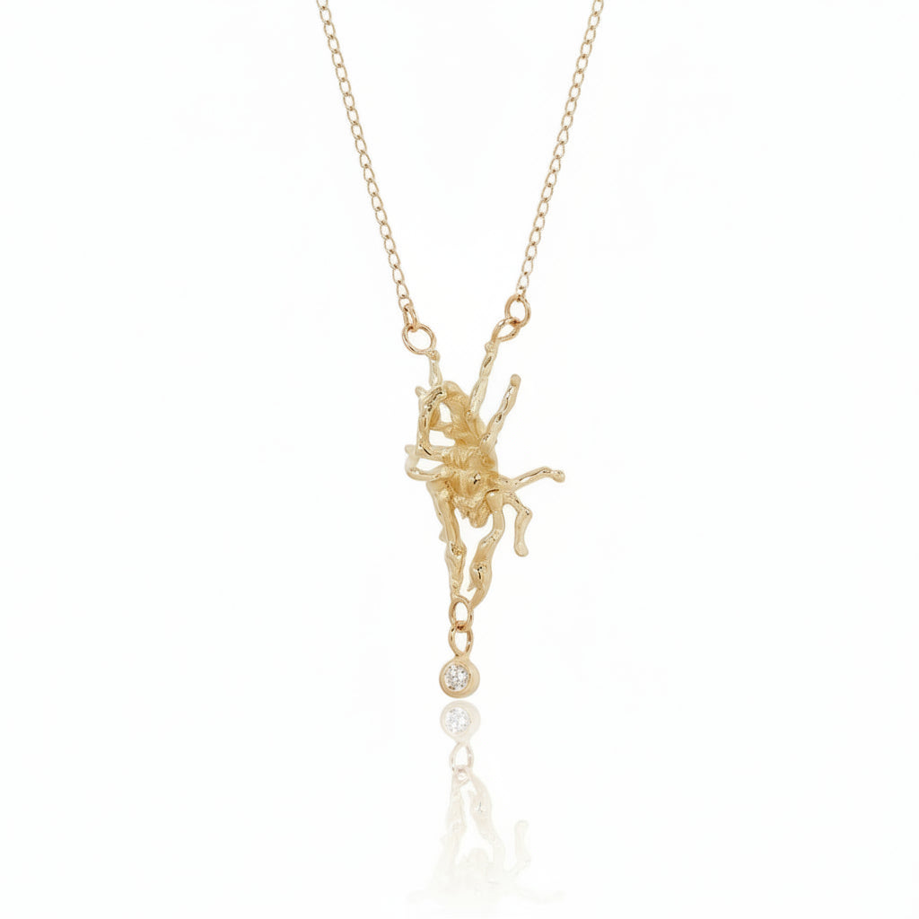 Hand-carved scorpion necklace by Alexis Pavlantos in solid 14k yellow gold, featuring a bezel-set round brilliant diamond dangling from its tail on a delicate 16-inch gold chain.