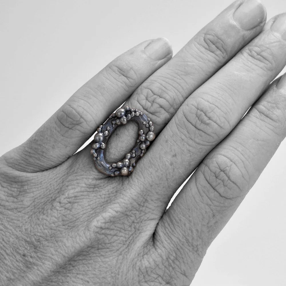 Cluster Circle Ring by Shaya Durbin worn on a hand, showing the sculptural open circle design and textured recycled sterling silver finish at natural scale.