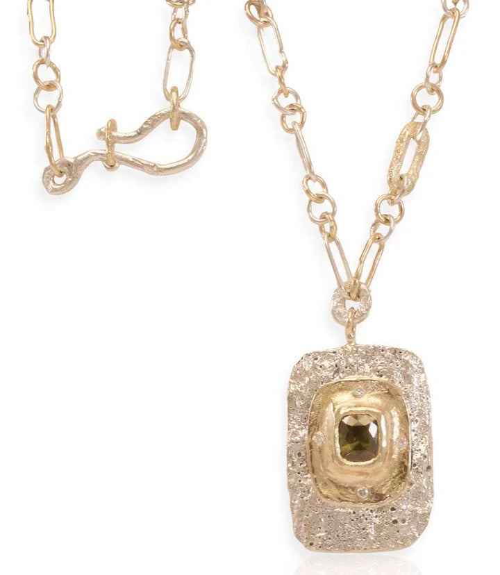 Full view of the Square Fragmented Pendant necklace showing its sculptural gold and silver setting, natural Montana sapphire, handmade chain, and rock-textured clasp.