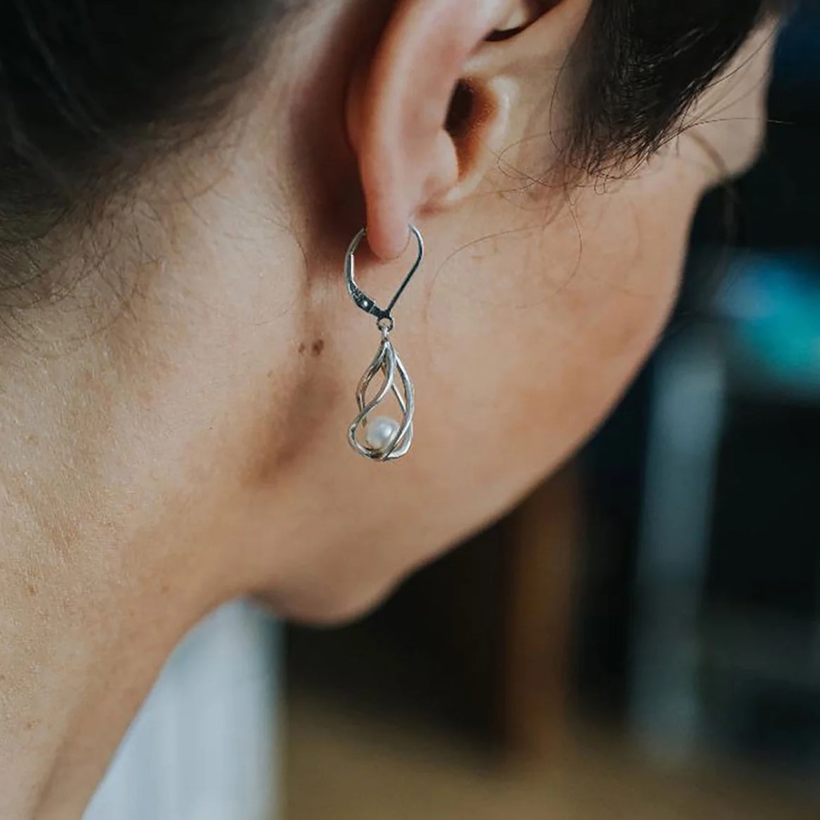 Side profile of a model wearing the Vine Earrings, showing their graceful sterling silver curves and dangling freshwater pearls.
