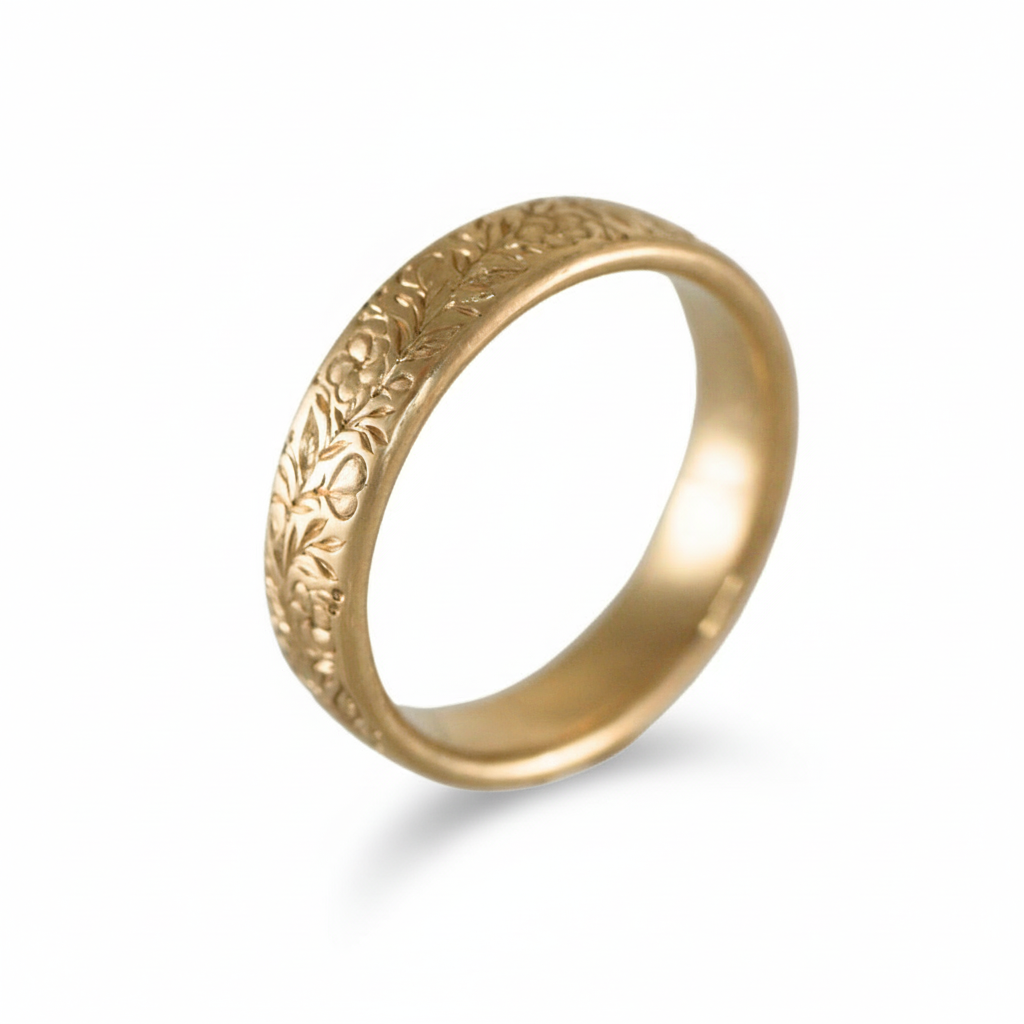 14k gold hand-engraved floral band ring shown at an angled view on a white background.