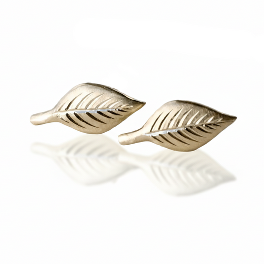 Close-up of 14k gold engraved leaf stud earrings with detailed hand engraving.