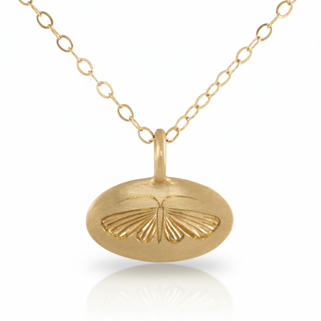 14k gold hand-engraved house moth pendant displayed on a chain against a white background.