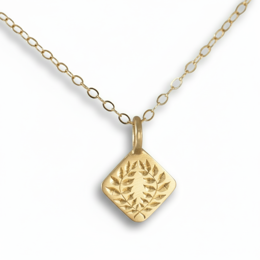 14k gold laurel square pendant necklace with hand-engraved leaf design on a white background.