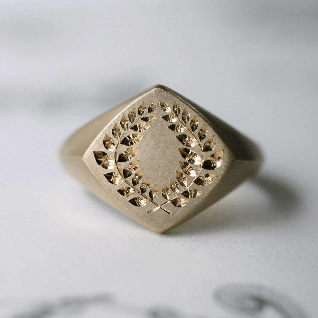 14k gold laurel square signet ring on white background – minimalist engraved gold ring