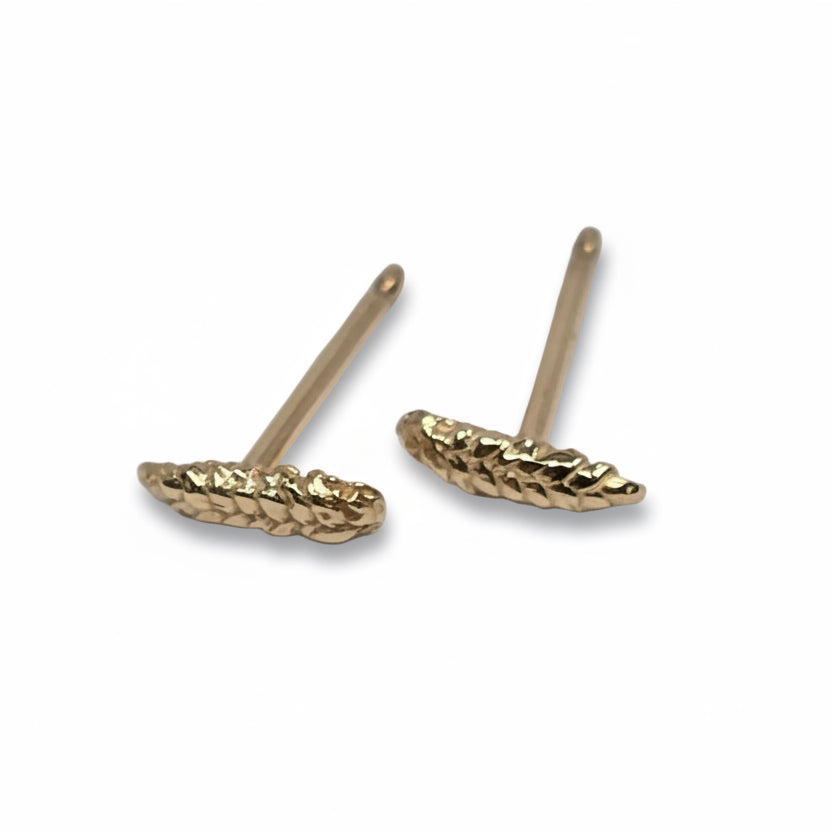 Angled view of 14k yellow gold wheat stud earrings showing their sculptural grain details and straight earring posts.