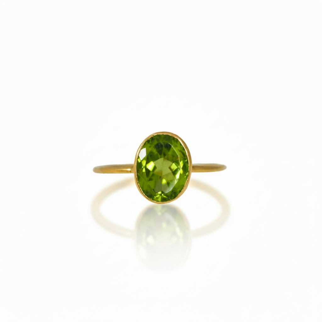 An 18k yellow gold ring with a faceted peridot stone set vertically on a minimalistic band.