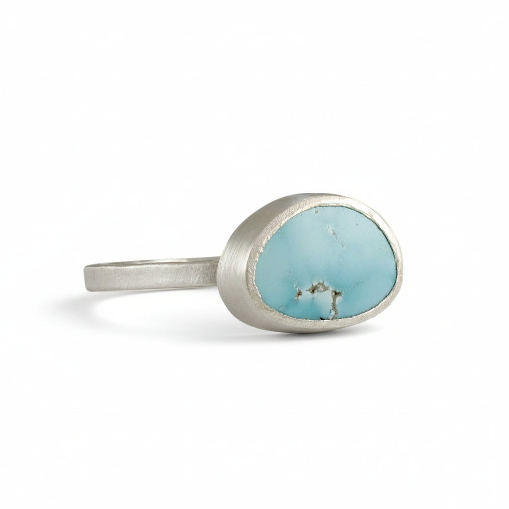Silver ring with a turquoise stone on a white background