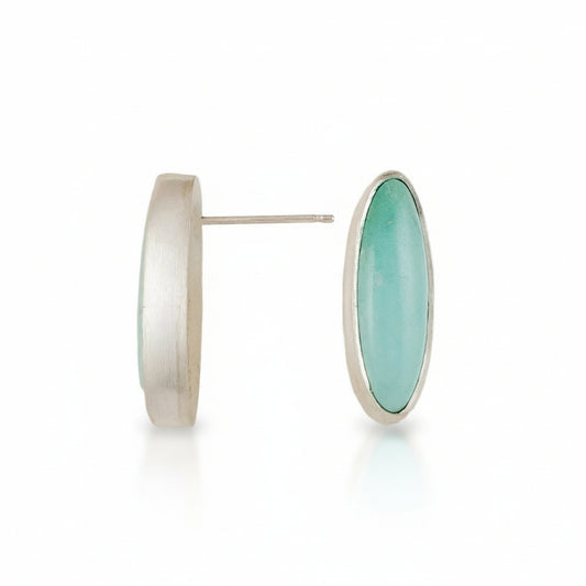 Silver earrings with a turquoise circular stone on a white background