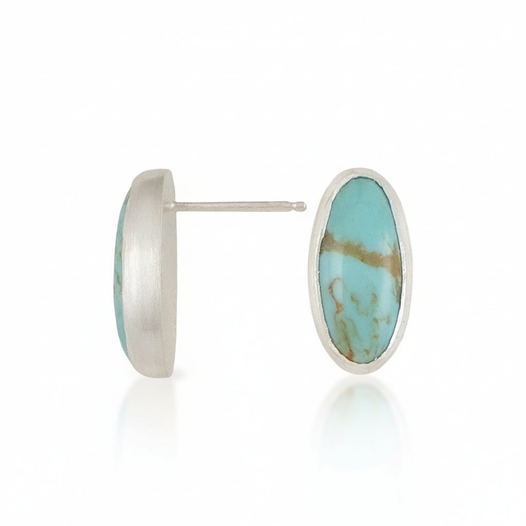Turquoise stone stud earrings with silver rims on a white background