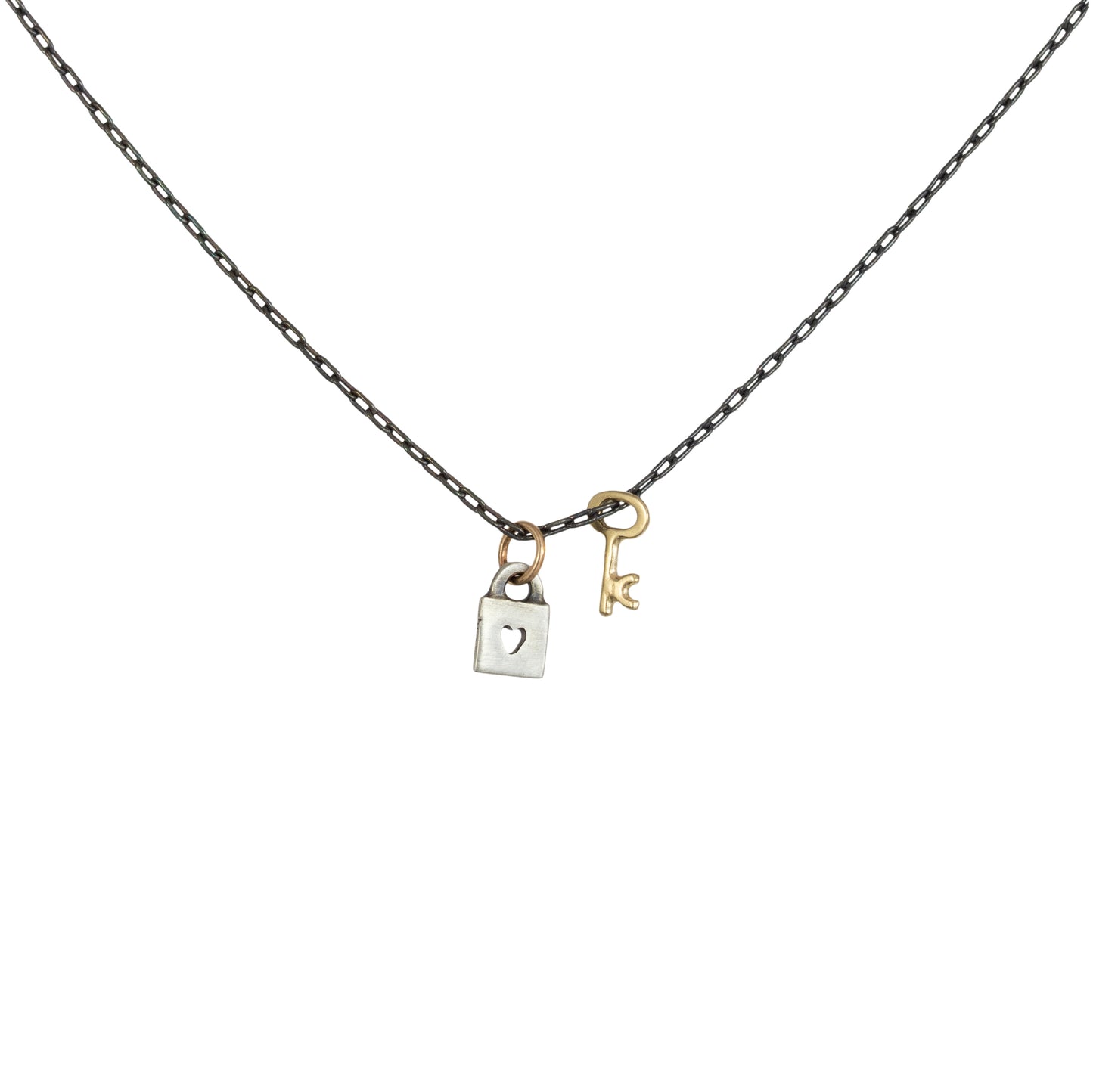 Tiny Love Lock with Key Necklace by Luana Coonen in 14k gold and sterling silver on white background