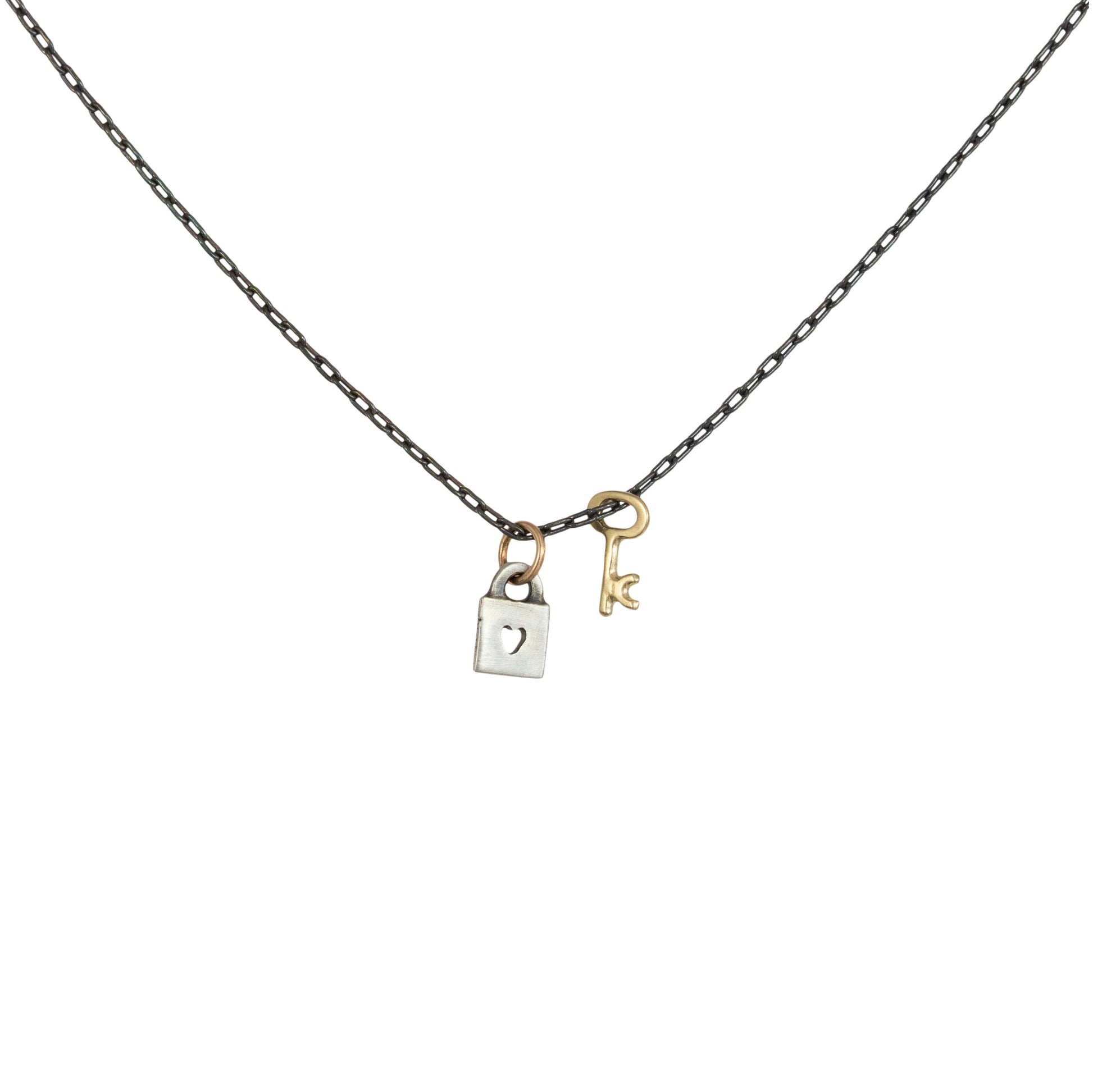 Tiny Love Lock with Key Necklace by Luana Coonen in 14k gold and sterling silver on white background