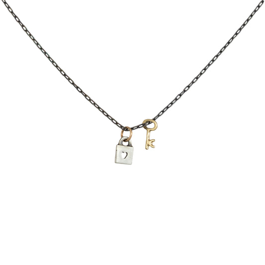 Tiny Love Lock with Key Necklace by Luana Coonen in 14k gold and sterling silver on white background