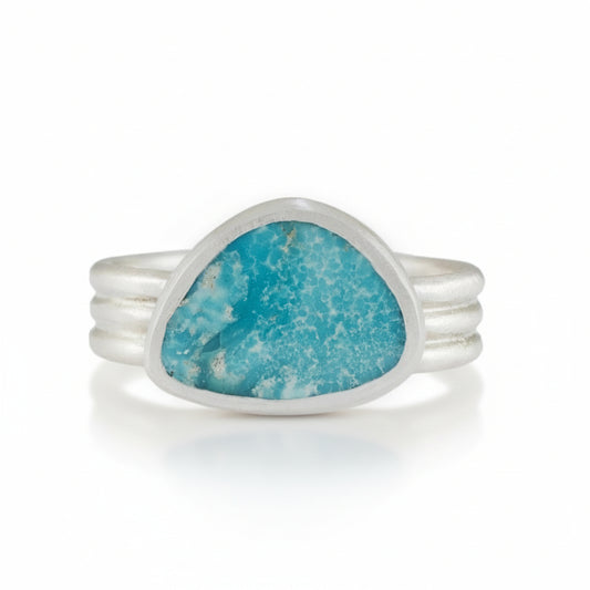 Silver ring with a turquoise stone on a white background