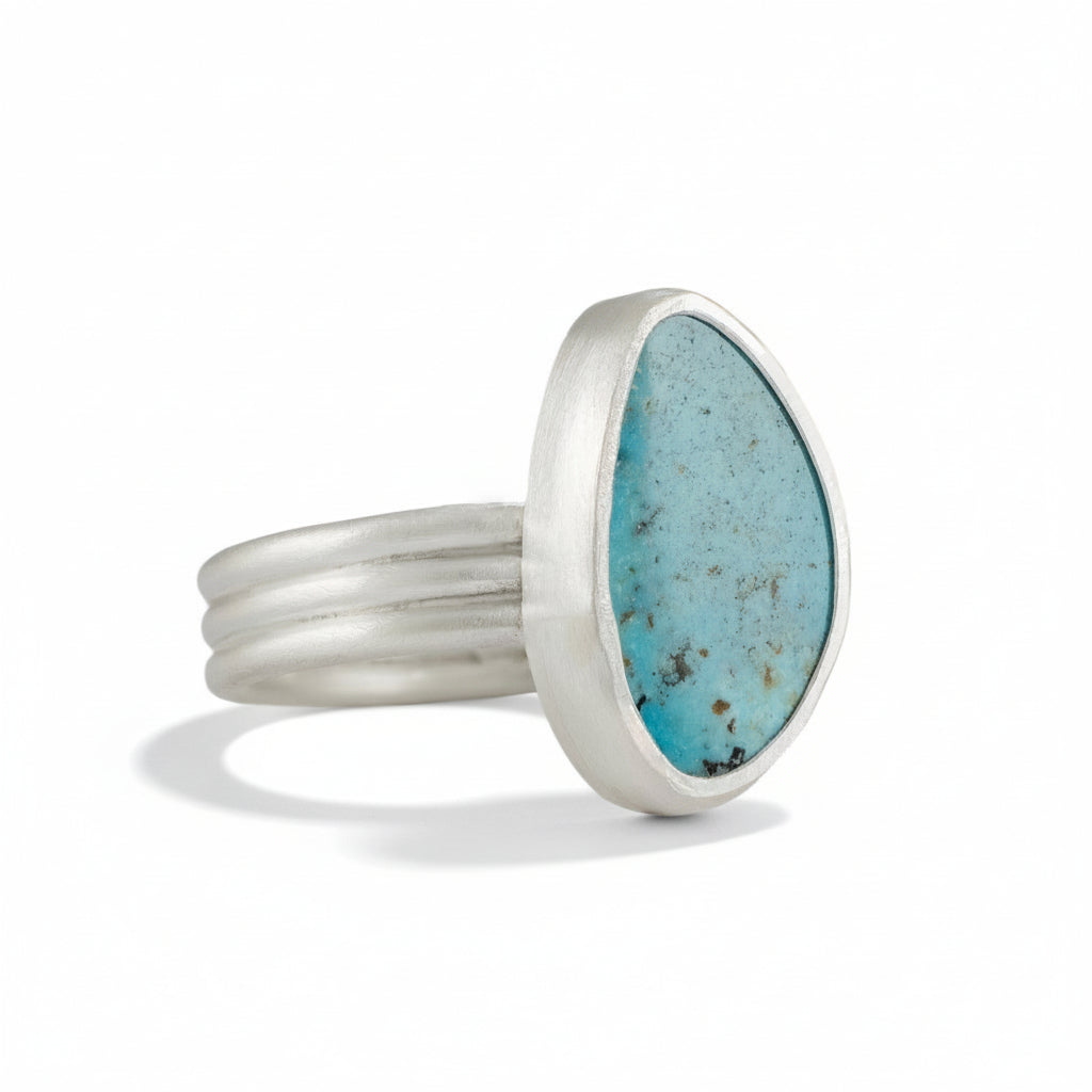 Sterling silver ring with a turquoise stone on a white background