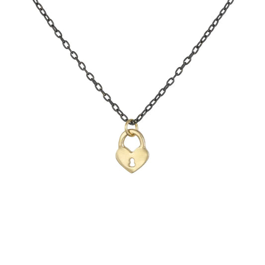 Gold heart-shaped lock pendant on an oxidized silver chain, Tiny Heart Lock Necklace by Luana Coonen, shown on white background.