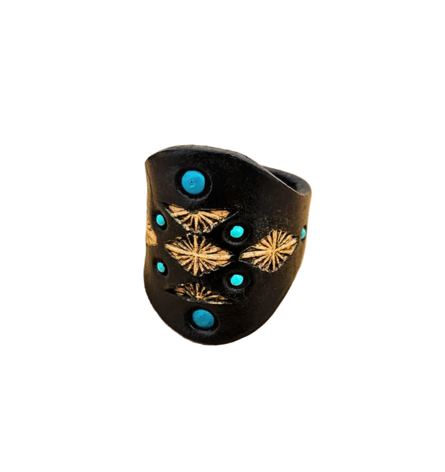 Detailed close-up of turquoise accents and tooled floral motifs on black leather ring.
