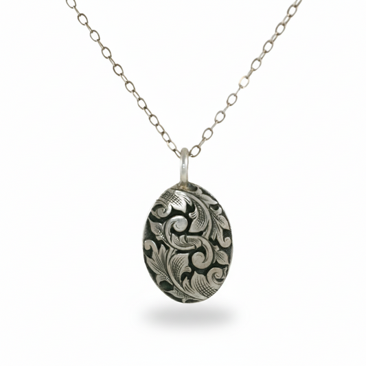 Front view of the hand-engraved sterling silver Acanthus oval pendant by Blue Blue Driver on an 18-inch chain.