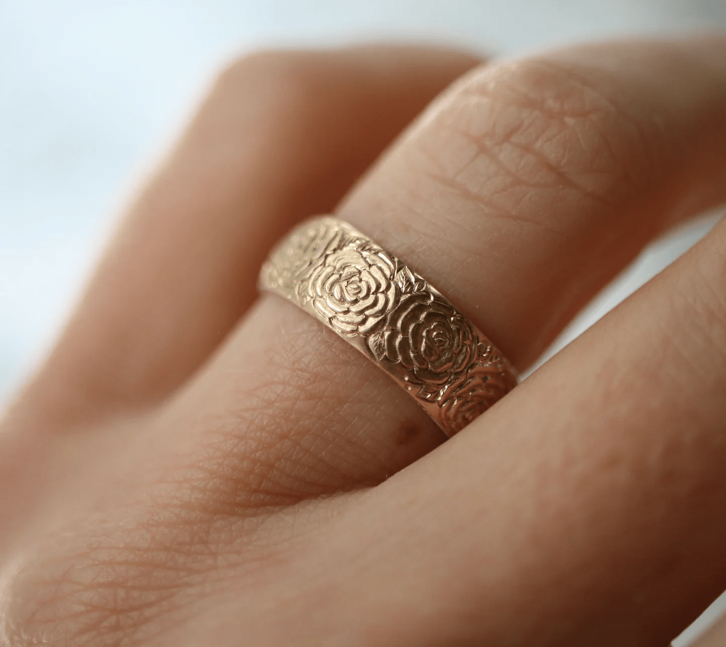 14k gold Beloved Rose band ring by Blue Blue Driver worn on hand, showing detailed engraving.