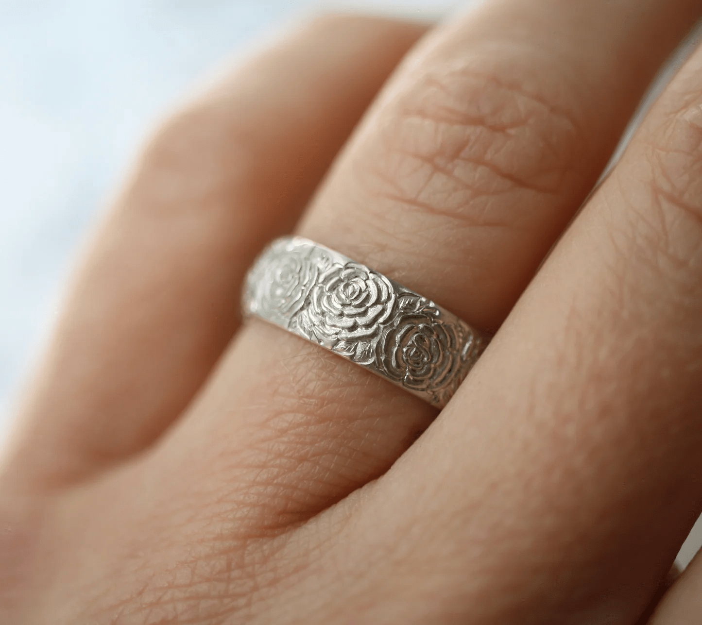 Sterling silver Beloved Rose band ring by Blue Blue Driver worn on hand, highlighting engraved details.
