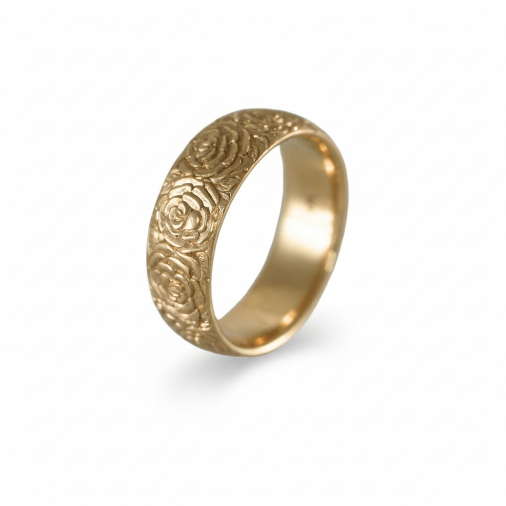 Angled view of the hand-engraved 14k yellow gold Beloved Rose band ring by Blue Blue Driver on a white background.