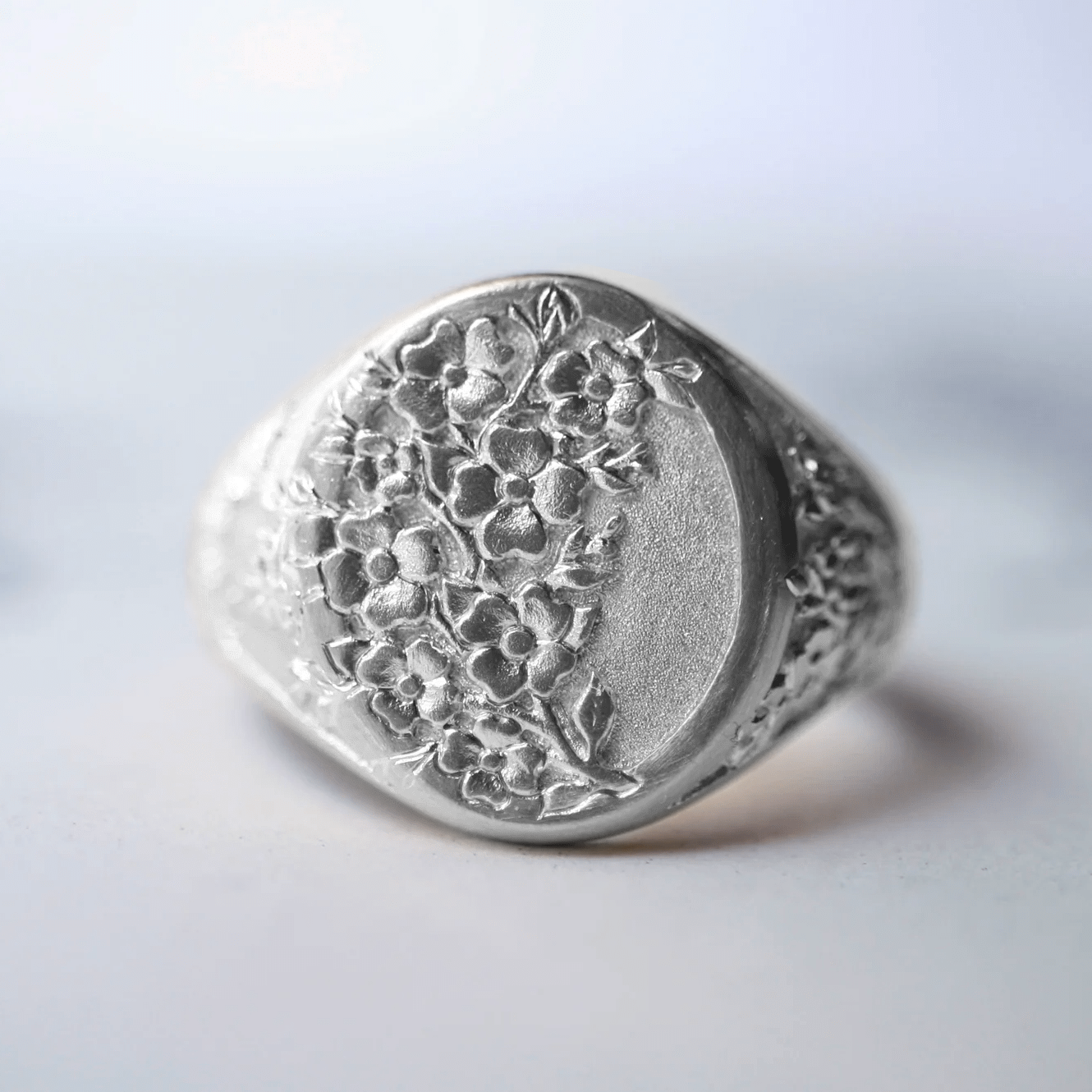 Sterling silver Dogwood signet ring shown from the front on a clean background.