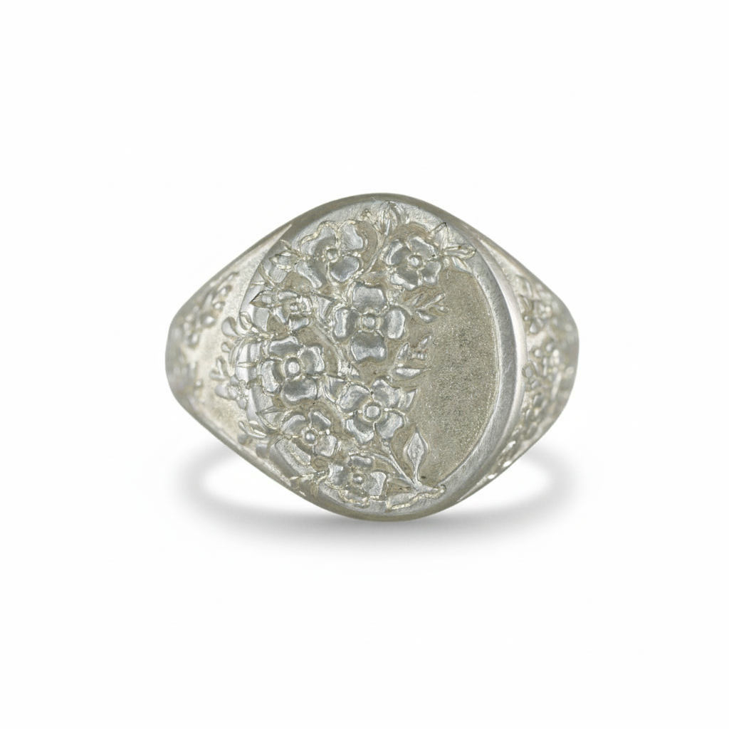 Silver dogwood signet ring with detailed floral engraving on a white background