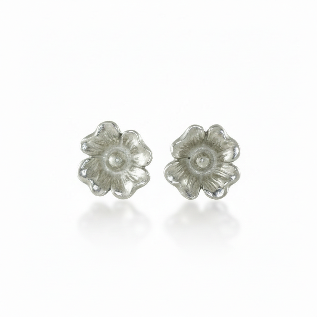 Pair of silver dogwood flower stud earrings on a white background