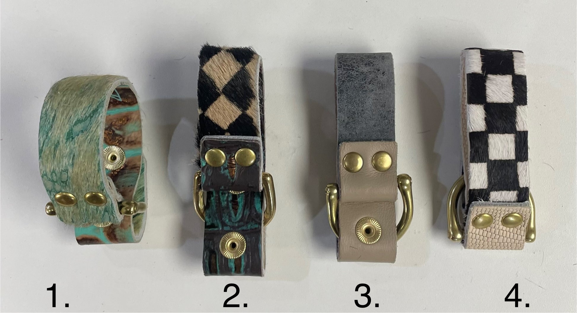 Leather cuff bracelet showing brass snap hardware and multicolor cowhide texture.