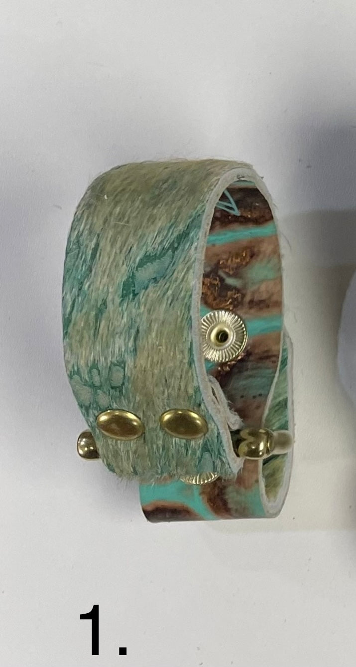 Neutral-toned leather cuff bracelet with brushed brass hardware.