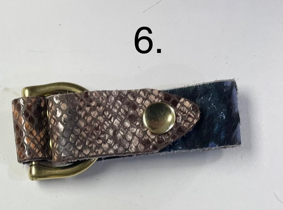 Dark textured cowhide cuff bracelet with brass hardware and rugged finish.