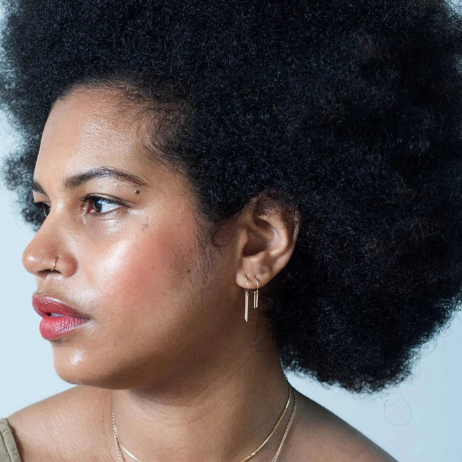 Model wearing the Chime and Baby Chime 14k gold earrings, showing minimalist stacked ear styling.