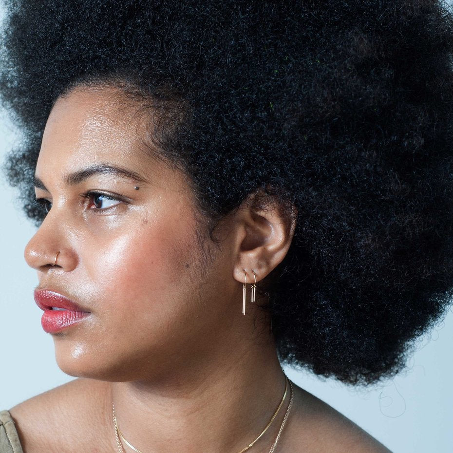 Side profile of model wearing the 14k gold Chime Earring.