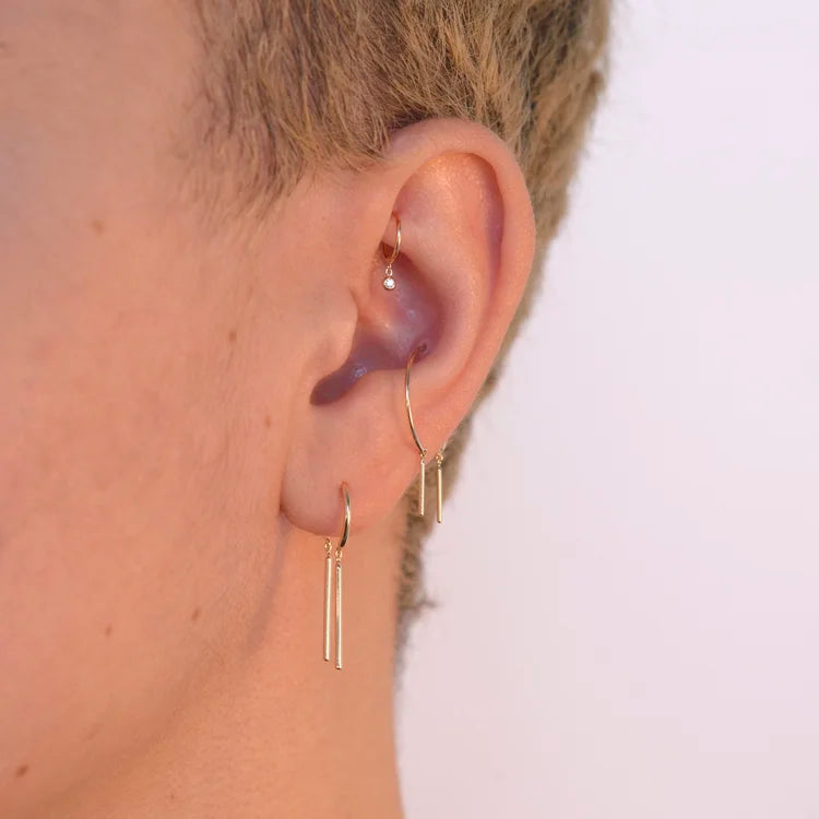 14k gold Chime Earring stacked with other hoops in a minimalist ear stack.