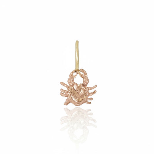 Hand-carved crab charm in solid 14k rose gold with a 14k yellow gold jump ring, featuring detailed claws, legs and a textured body.