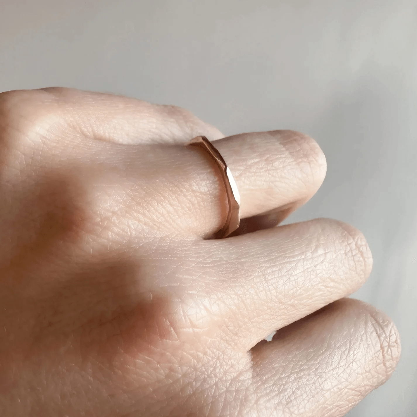 Crag Ring in 14k yellow gold shown on hand, highlighting its faceted raw texture