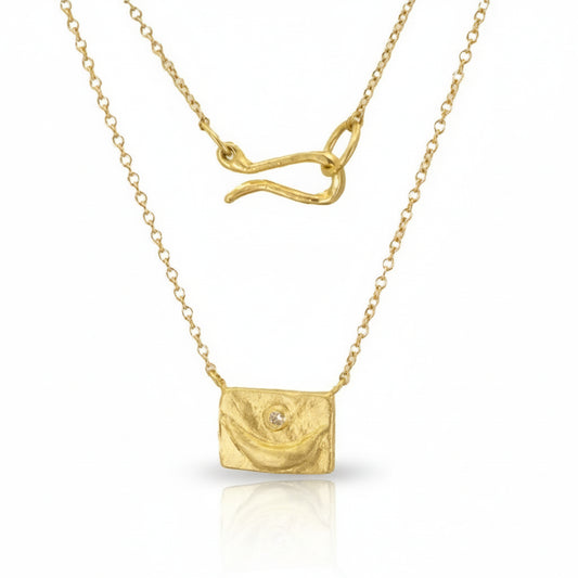 Hand-carved 18k yellow gold Crescent Portrait Pendant by Erin Cuff featuring a reclaimed white diamond on a delicate gold chain with an S-hook clasp.
