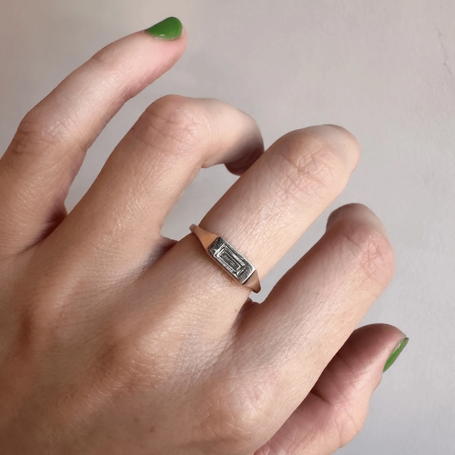 14k yellow gold diamond baguette signet ring worn on hand in natural light.