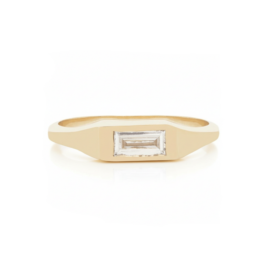 14k yellow gold signet ring by Adeline Jewelry with a horizontal 0.3 carat white baguette diamond set into a polished tapered band on white.
