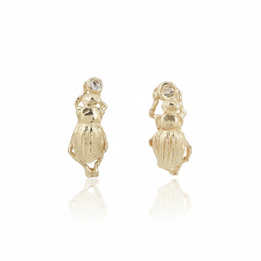 Pair of handcrafted beetle stud earrings in recycled 14k yellow gold by Alexis Pavlantos, featuring sculpted insect details and repurposed round brilliant-cut diamonds.