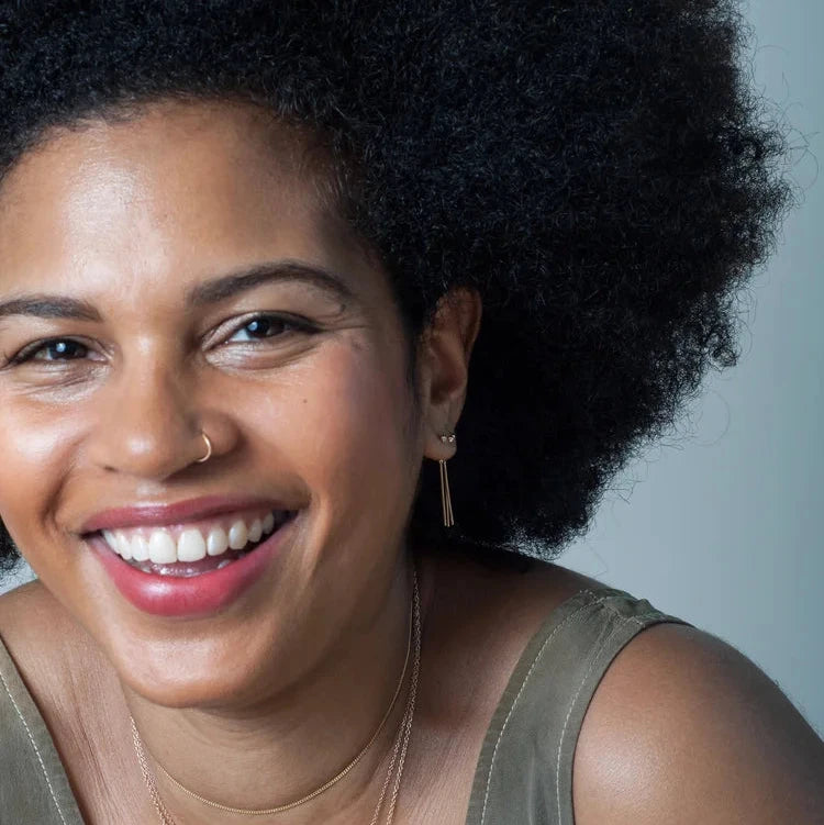 Model wearing the 14k gold Diamond Chime Stud earring, smiling