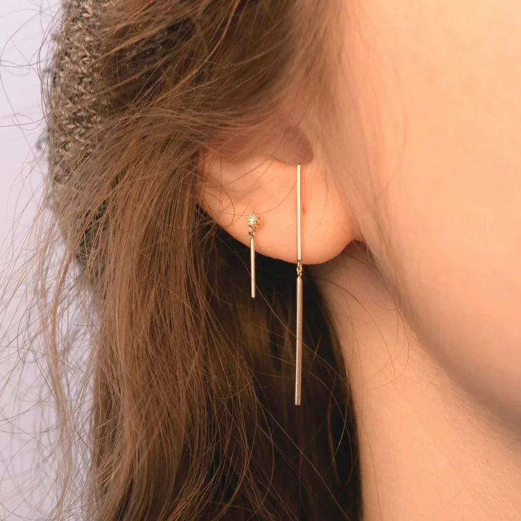 Model wearing the Diamond Wisp 14k gold stick earring for a clean minimalist look.