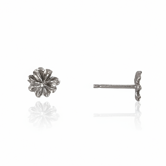 Front and side views of Efflorescent Small Stud Earrings in sterling silver by Alexis Pavlantos, featuring hand-carved floral petals, a 5mm diameter, and delicate post closures.