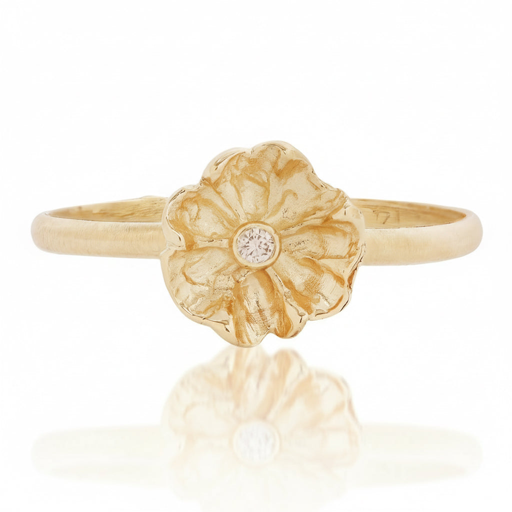 Front view of the Efflorescent Stacking Ring by Alexis Pavlantos, featuring a hand-carved floral design in solid 14k yellow gold with a flush-set 1.5mm natural diamond at its center.