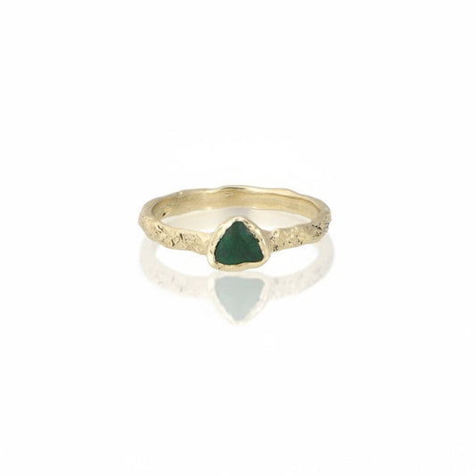 Emerald Trillion Metamorphic Ring by Alexis Pavlantos, featuring a 0.30 carat trillion-cut green emerald in a sculptural rock-textured 14k yellow gold band.