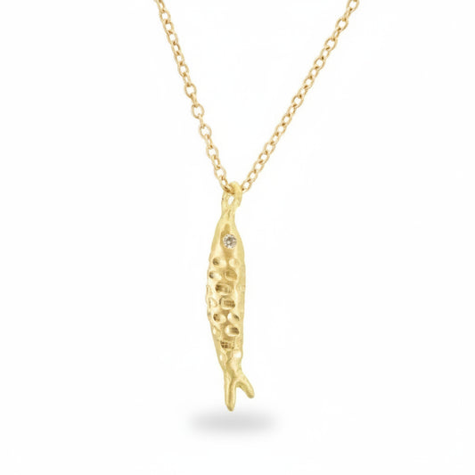 Hand-engraved 18k yellow gold fish pendant by Erin Cuff featuring reclaimed white diamond eyes on a delicate gold chain.