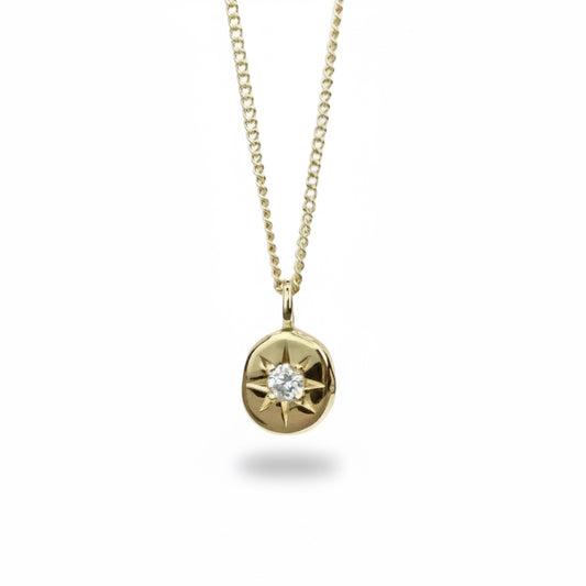 Estrella Diamond Star Necklace by Ladha Jewelry, featuring a white diamond set in an 11mm solid 14k yellow gold pendant on an 18-inch curb chain.