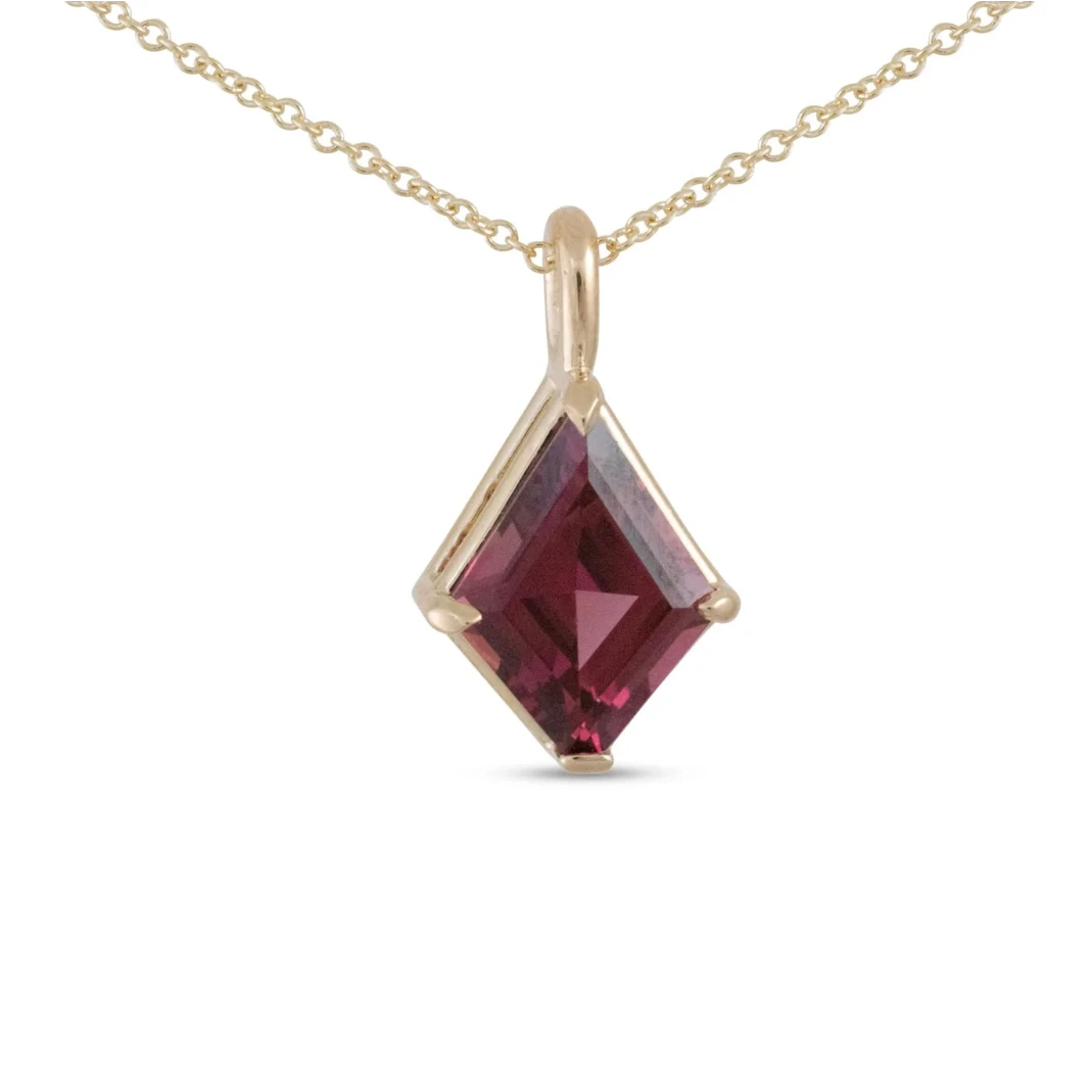 One-of-a-kind rhodolite garnet kite pendant by Michaela Farkasovska, featuring a geometric deep raspberry gemstone set in 14k yellow gold.